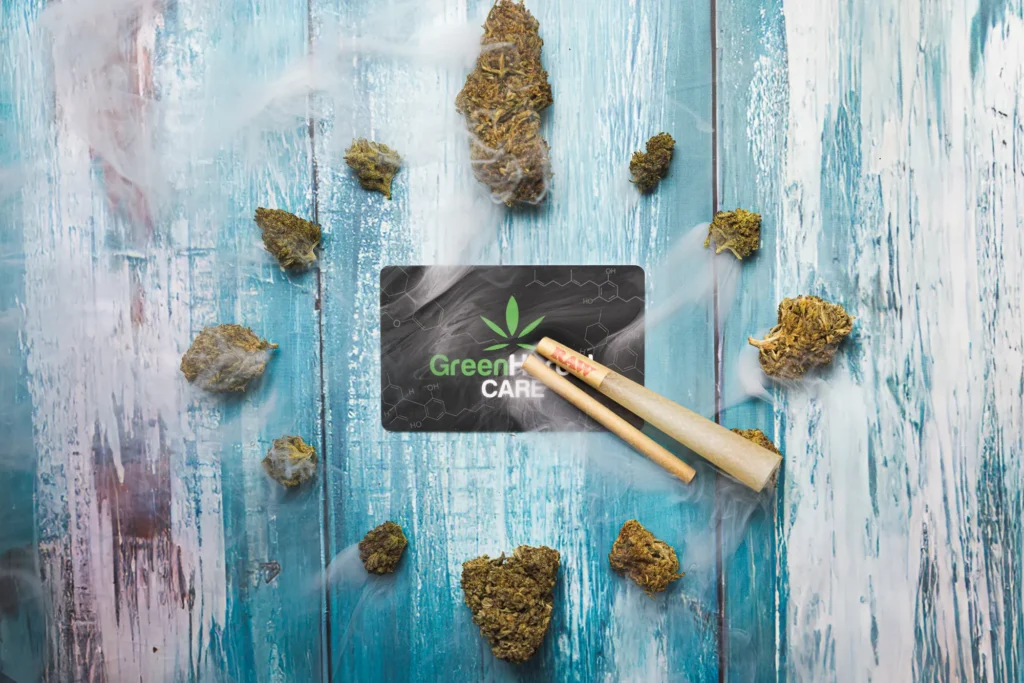 Styled product flat lay on blue wood with small cannabis nuggets arranged around a branded card
