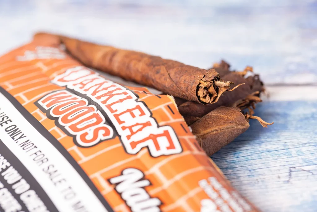 Product photo of a packaged cigar on a bright textured wood surface