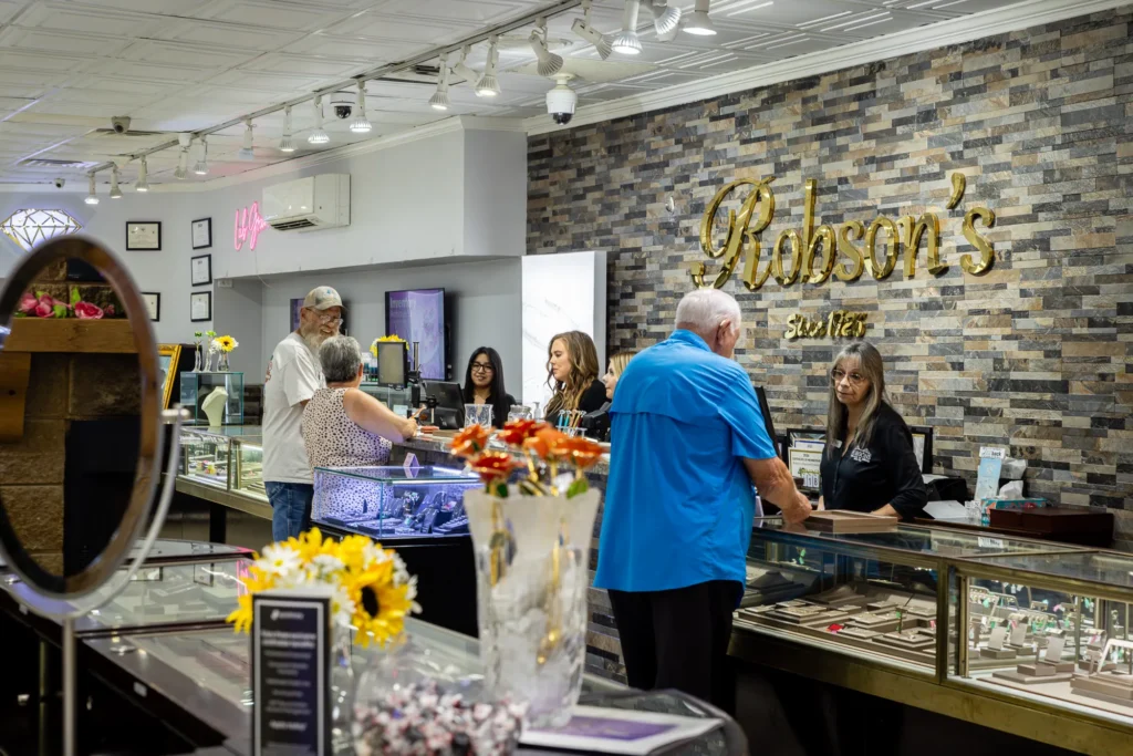 Customers being helped at a jewelry counter inside Robson's Jewelry