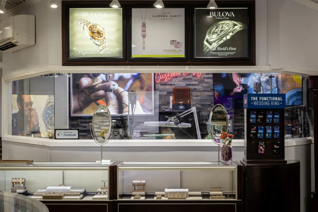 Jewelry showroom interior with display cases, a jeweler's workstation, and branded store details