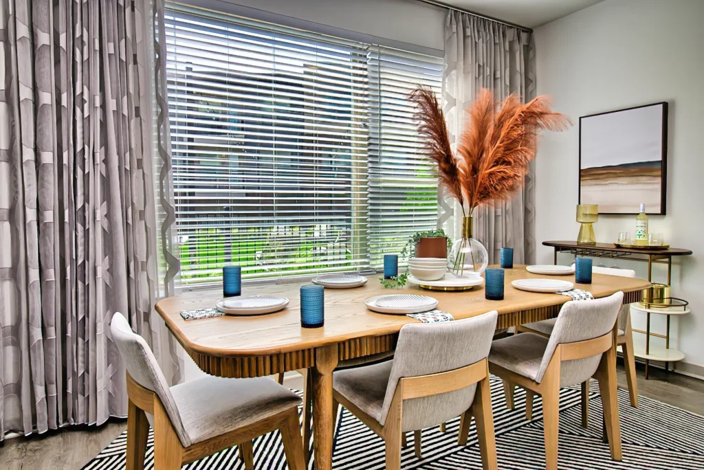 Interior photography of a dining room with a round table, pampas centerpiece, and natural light
